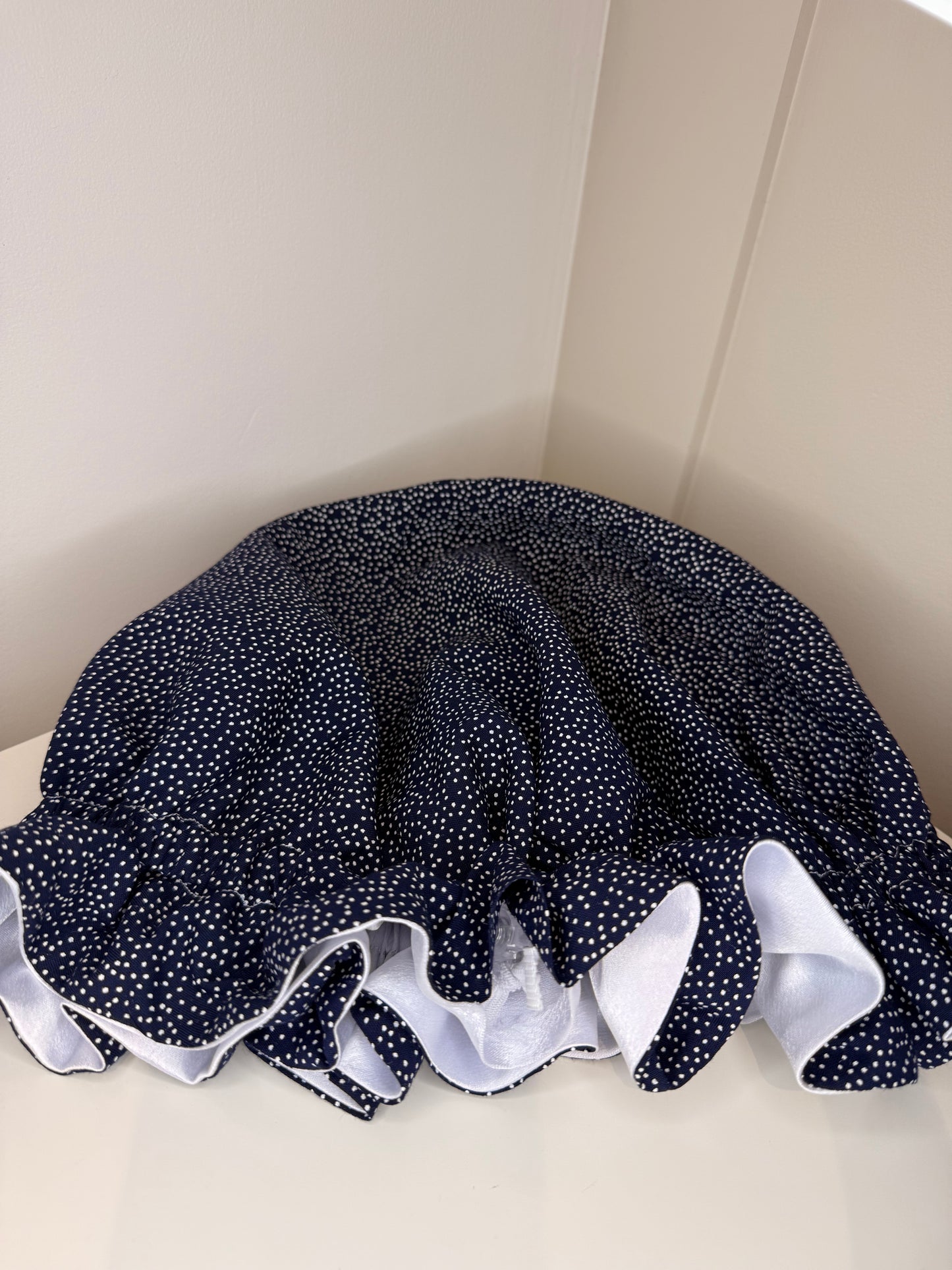 Navy blue night sky looking bonnet with white satin, closed and showing the adjustable toggle
