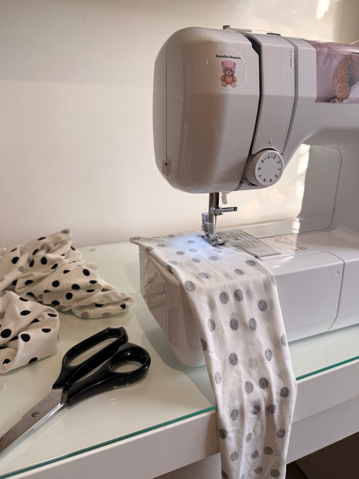 sewing machine with white and black polka dot fabric and scissors 