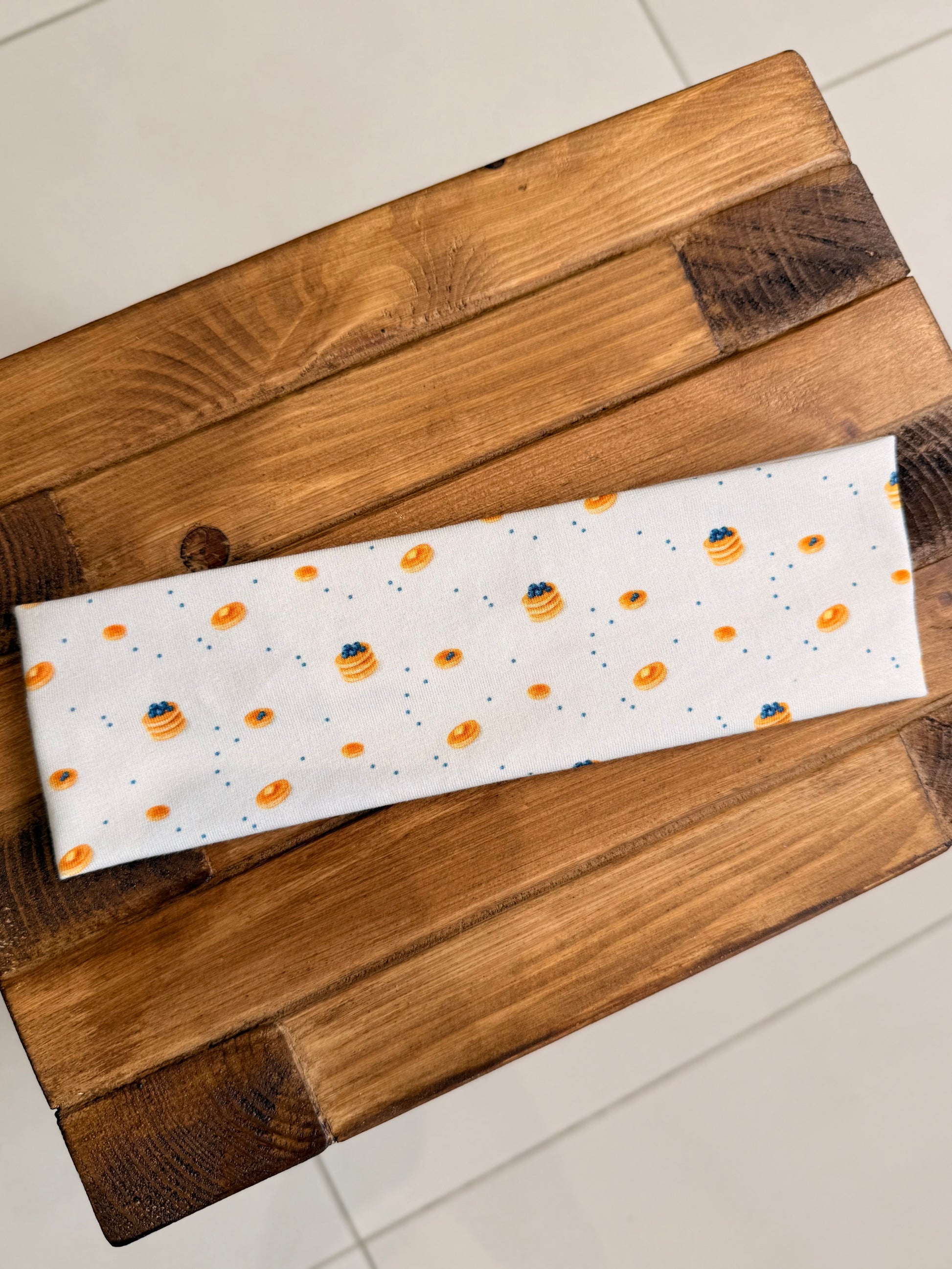 blueberry print Fabric headband on a wooden surface