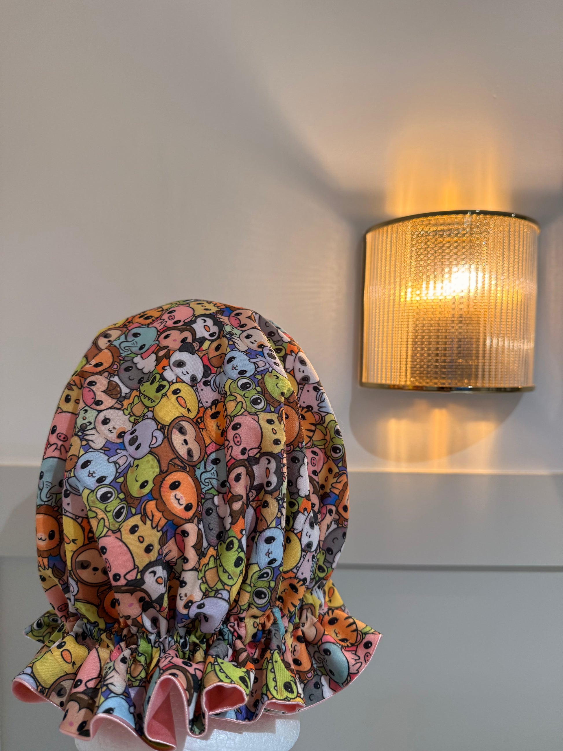 animal print bonnet with baby pink satin against a plain background with warm lighting 