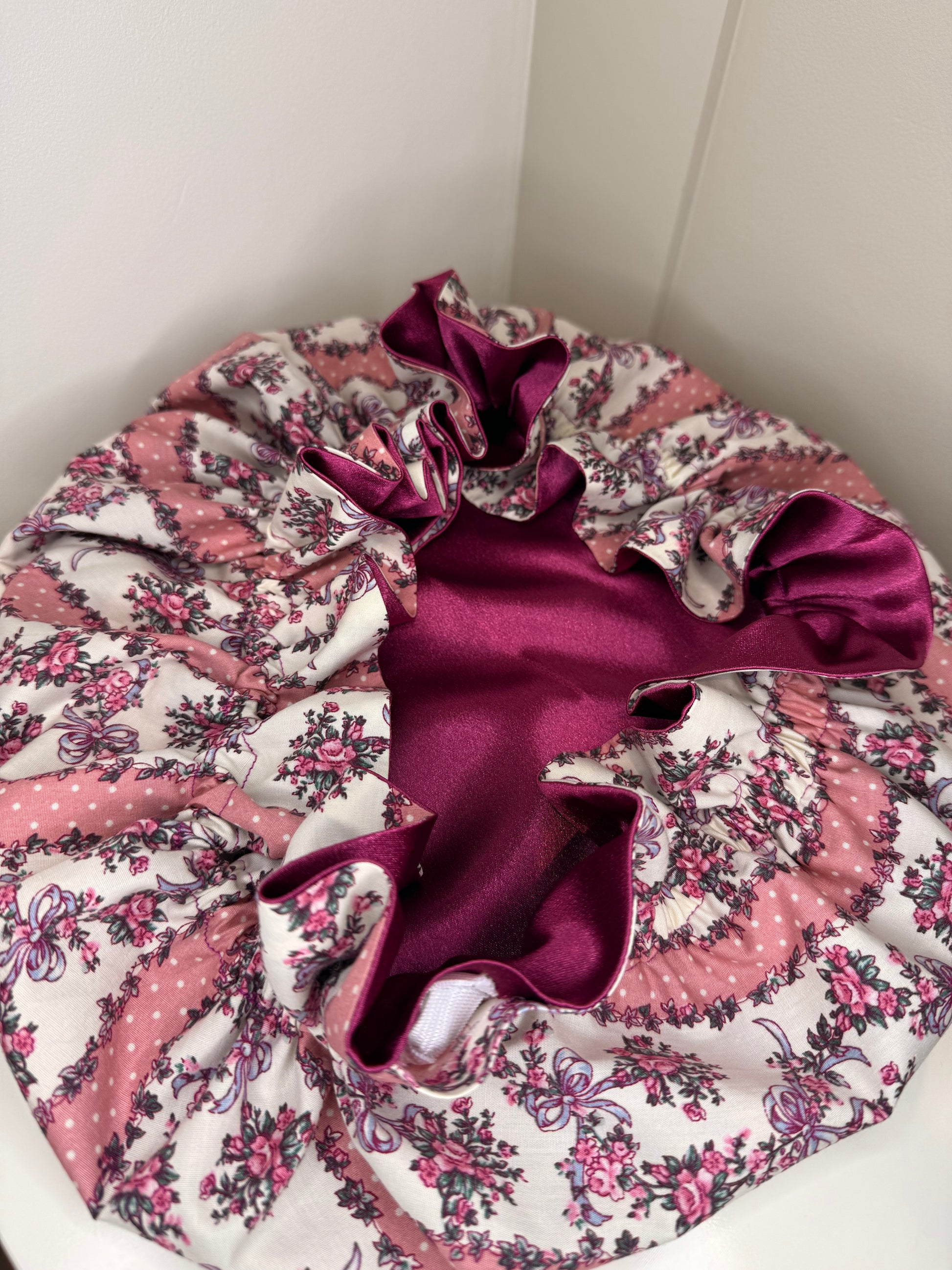 Floral fabric bonnet with deep purple satin on a white background