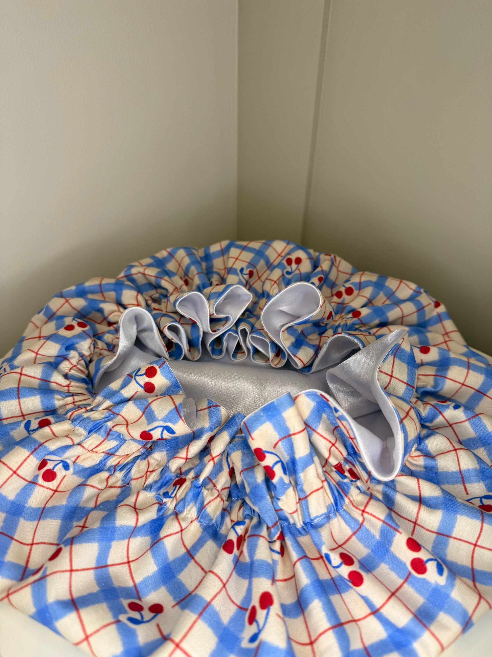 Folded bonnet with blue, red, and white pattern on a plain background